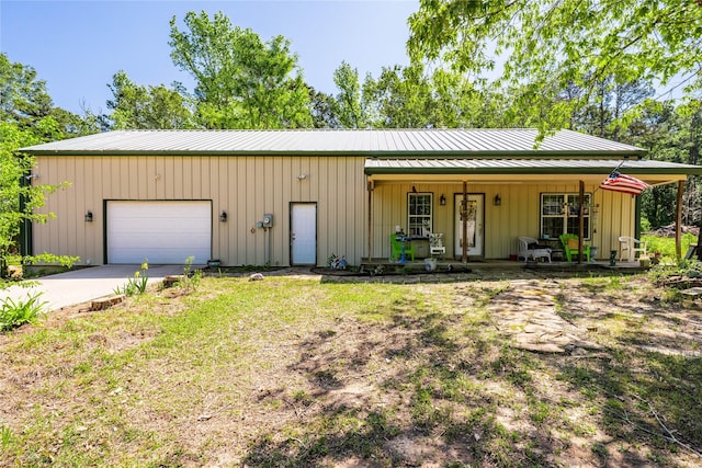 exterior space featuring a porch, metal roof, concrete driveway, a garage, and board and batten siding