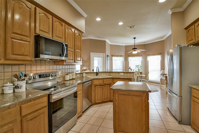 kitchen featuring backsplash, a sink, a peninsula, appliances with stainless steel finishes, and ceiling fan