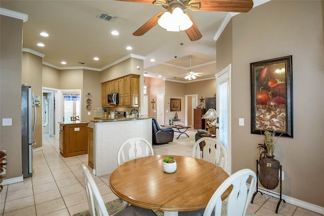 dining room with crown molding, light tile patterned floors, ceiling fan, baseboards, and visible vents