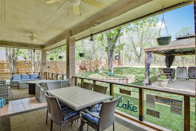 sunroom with outdoor dining space, ceiling fan, and an outdoor hangout area