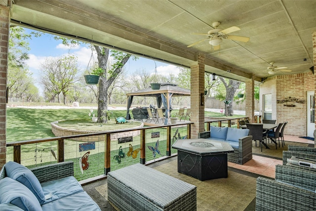 sunroom / solarium with ceiling fan, outdoor dining area, and an outdoor living space with a fire pit