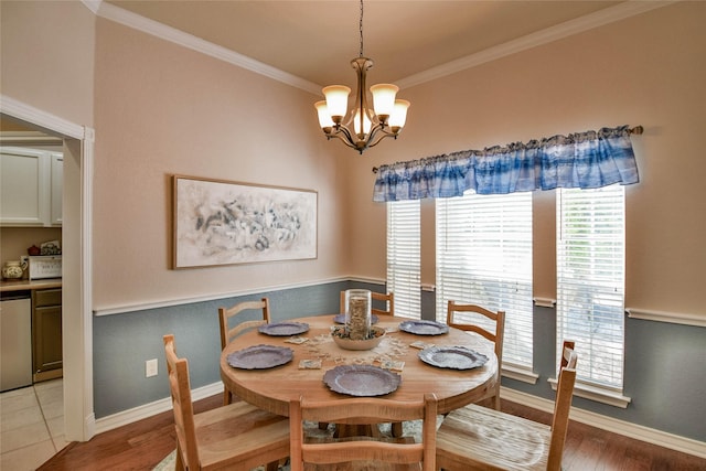 dining area with baseboards, light wood-style floors, a chandelier, and crown molding