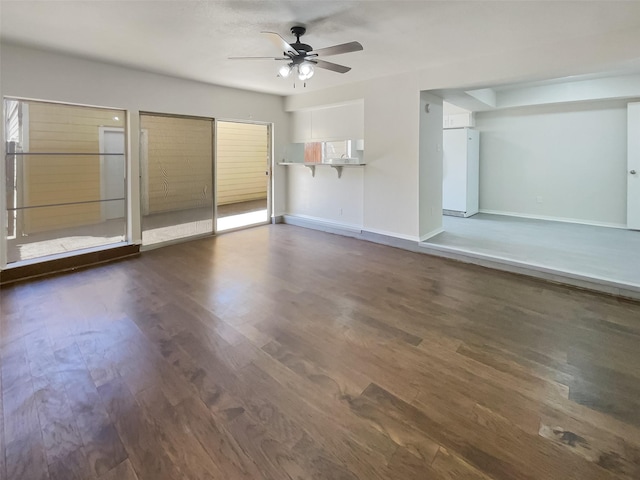 unfurnished living room featuring ceiling fan, baseboards, and wood finished floors