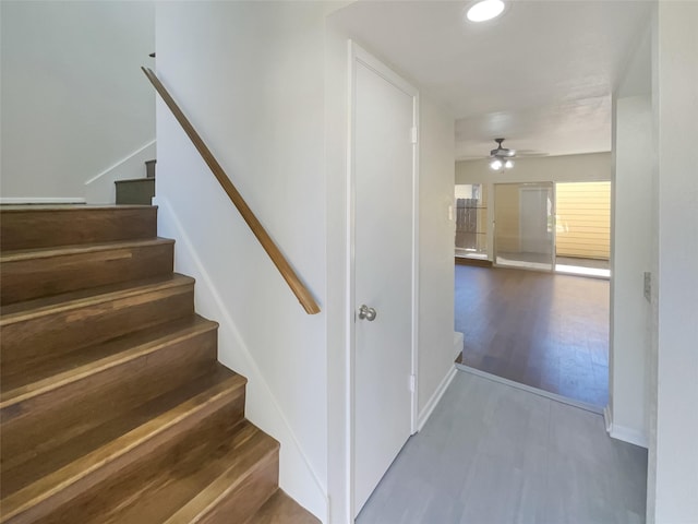 stairway with recessed lighting, wood finished floors, a ceiling fan, and baseboards