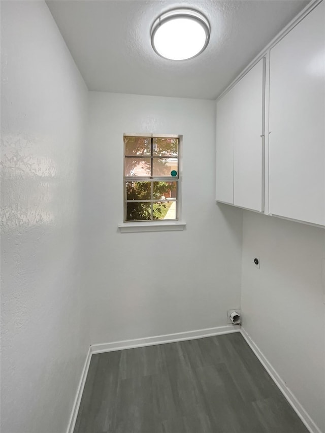 laundry room with baseboards, cabinet space, electric dryer hookup, and dark wood-style floors