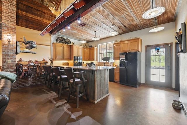 1350 Bennett Rd, Millsap, TX 76066 - kitchen with a kitchen breakfast bar, concrete flooring, a healthy amount of sunlight, and black fridge