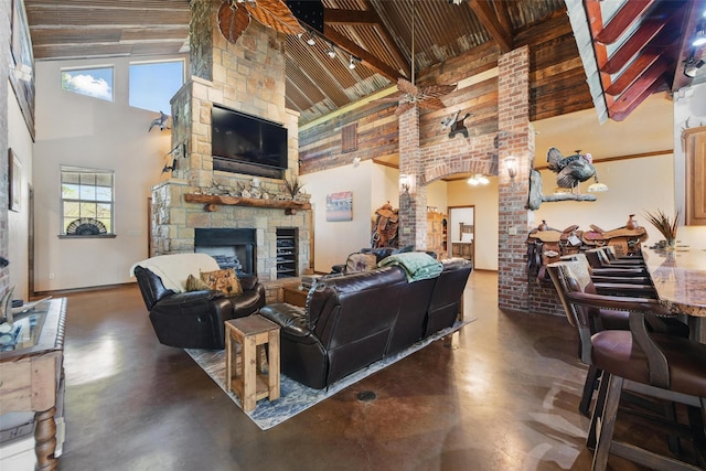 1350 Bennett Rd, Millsap, TX 76066 - living room featuring a stone fireplace, a high ceiling, finished concrete flooring, and wood ceiling