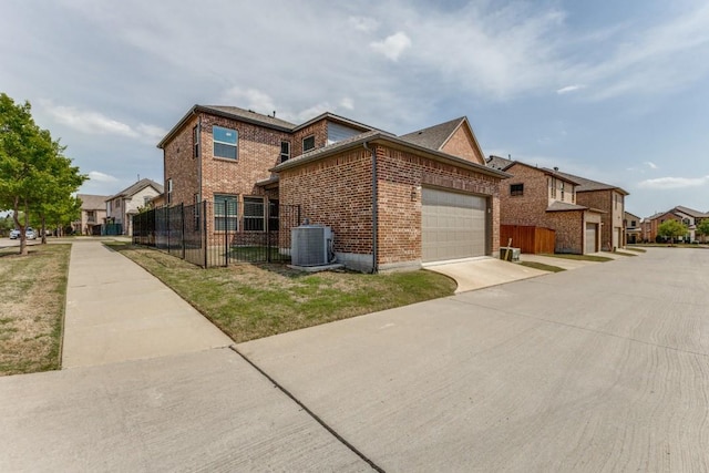 view of home's exterior featuring central air condition unit, driveway, fence, brick siding, and an attached garage