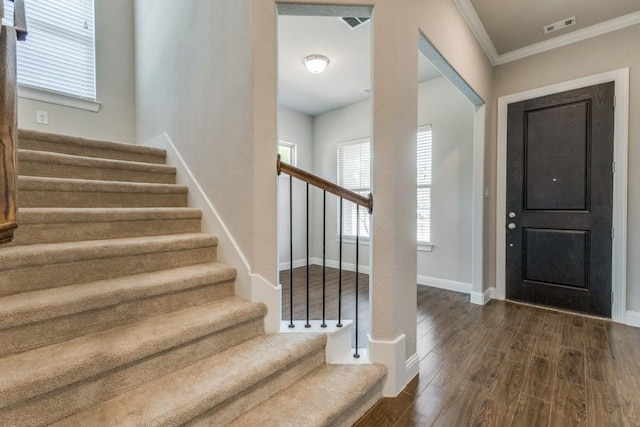 foyer entrance featuring dark wood-style floors, stairs, visible vents, and plenty of natural light