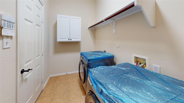 washroom featuring washer / dryer, cabinet space, and baseboards