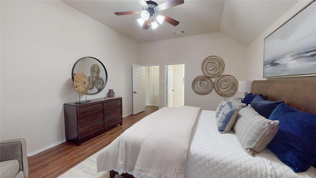 bedroom with a ceiling fan, wood finished floors, baseboards, lofted ceiling, and visible vents