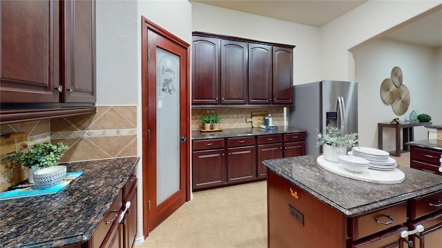 2420 Alta Vista Dr, Denton, TX 76210 - kitchen featuring stainless steel fridge, decorative backsplash, a center island, and dark stone countertops