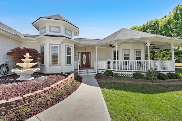 view of front of home featuring a front lawn, roof with shingles, brick siding, a ceiling fan, and a porch