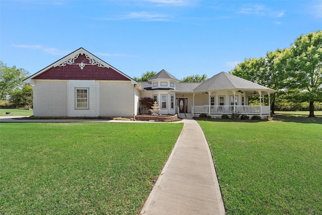 view of front facade with covered porch, brick siding, ceiling fan, and a front lawn