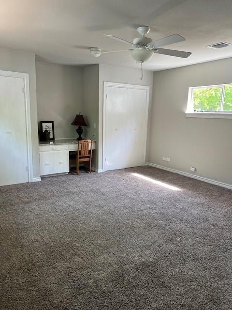 unfurnished bedroom featuring baseboards, a ceiling fan, visible vents, and carpet