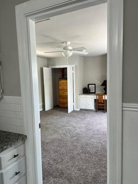 unfurnished bedroom featuring ceiling fan and carpet
