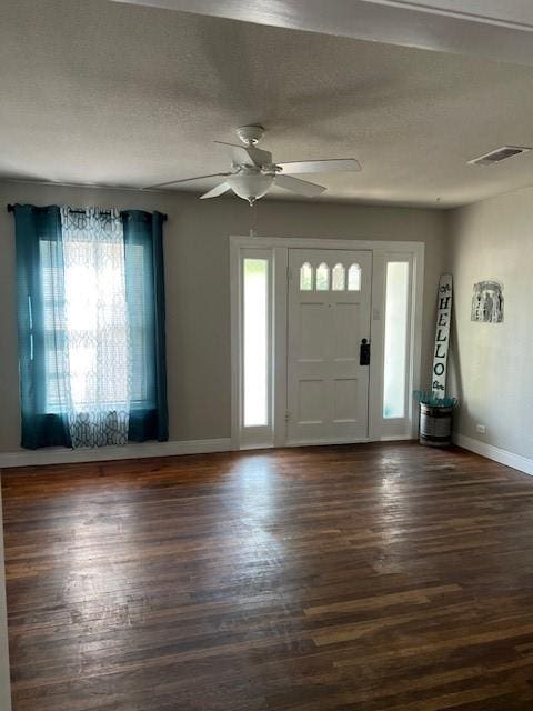 foyer entrance featuring baseboards, visible vents, ceiling fan, and dark wood finished floors