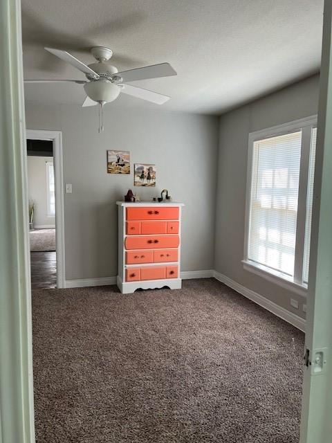 unfurnished bedroom featuring baseboards, carpet floors, and ceiling fan