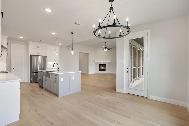 1525 Wild Indigo Dr, Mansfield, TX 76063 - kitchen with a sink, a center island with sink, visible vents, freestanding refrigerator, and light countertops