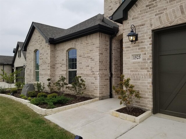 1525 Wild Indigo Dr, Mansfield, TX 76063 - doorway to property with a chimney, brick siding, a shingled roof, and a garage