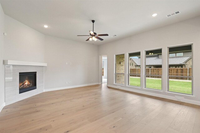 1525 Wild Indigo Dr, Mansfield, TX 76063 - unfurnished living room with light wood-style floors, a tile fireplace, and recessed lighting