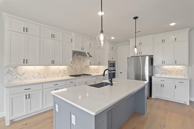 1525 Wild Indigo Dr, Mansfield, TX 76063 - kitchen featuring stainless steel appliances, under cabinet range hood, visible vents, a sink, and decorative backsplash