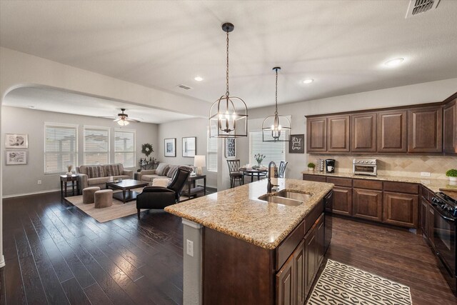14116 Rabbit Brush Ln, Fort Worth, TX 76052 - kitchen featuring arched walkways, a sink, visible vents, black range with gas cooktop, and light stone counters