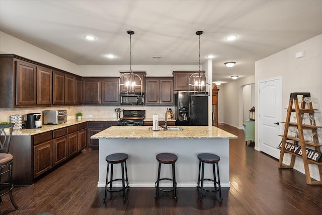 14116 Rabbit Brush Ln, Fort Worth, TX 76052 - kitchen with a notable chandelier, dark brown cabinetry, a sink, and black appliances