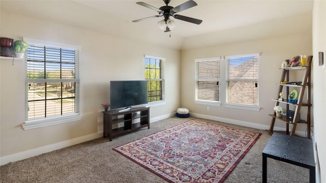 living area with carpet flooring, baseboards, and ceiling fan