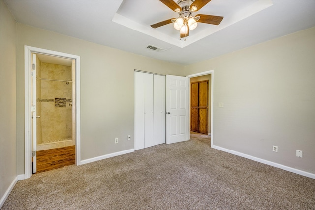 unfurnished bedroom featuring visible vents, connected bathroom, carpet floors, a closet, and baseboards