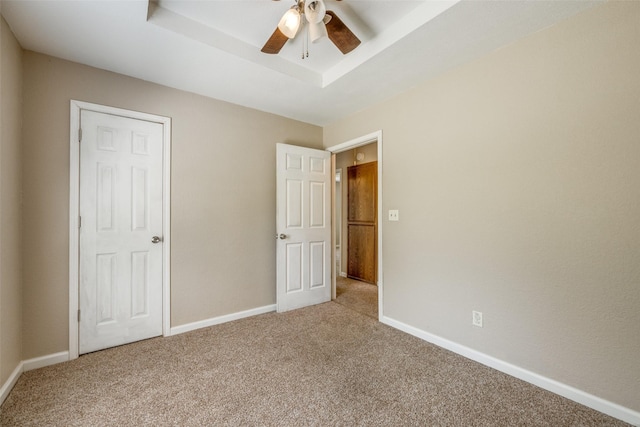 unfurnished bedroom featuring carpet, a ceiling fan, and baseboards