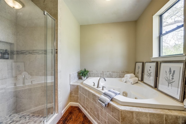 bathroom featuring a shower stall, wood finished floors, and a jetted tub