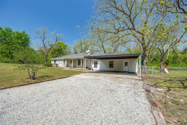 ranch-style house with fence, a front lawn, driveway, and an attached carport