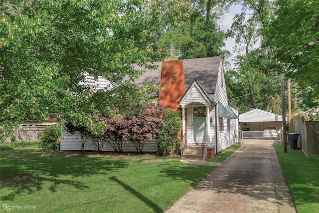 view of front of house with driveway, a front lawn, and fence