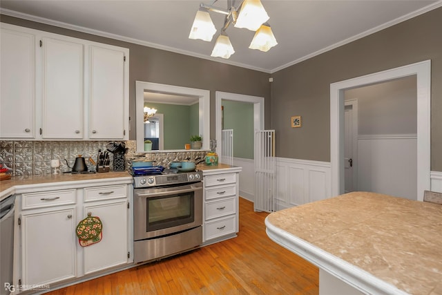 kitchen with an inviting chandelier, stainless steel appliances, light wood finished floors, and light countertops