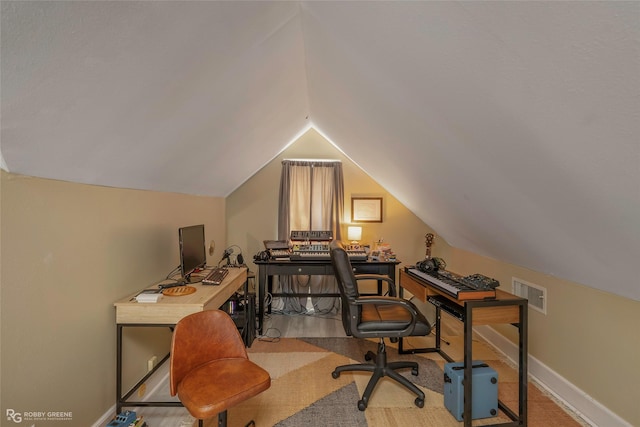 office with vaulted ceiling, visible vents, and baseboards