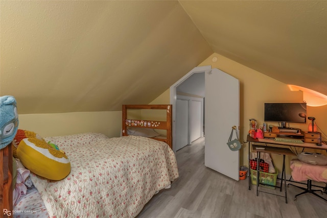 bedroom featuring vaulted ceiling and wood finished floors