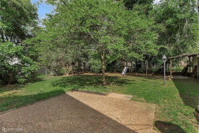 view of yard with a patio area, a fenced backyard, and a playground