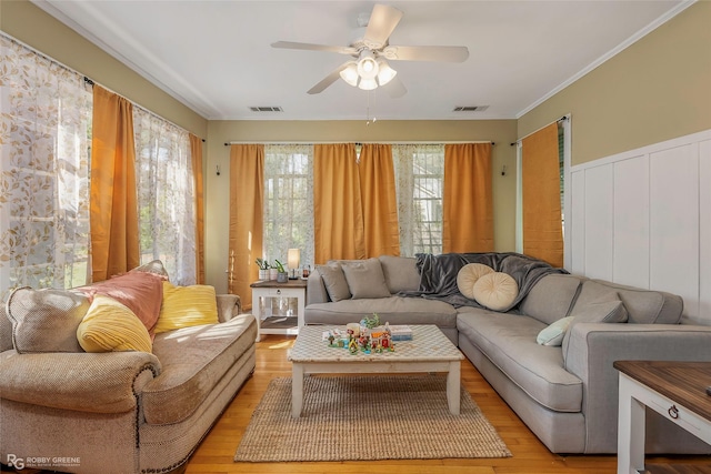 living area featuring visible vents, ceiling fan, and a healthy amount of sunlight