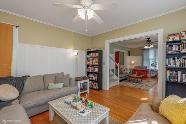 living area featuring ornamental molding, a ceiling fan, and light wood finished floors