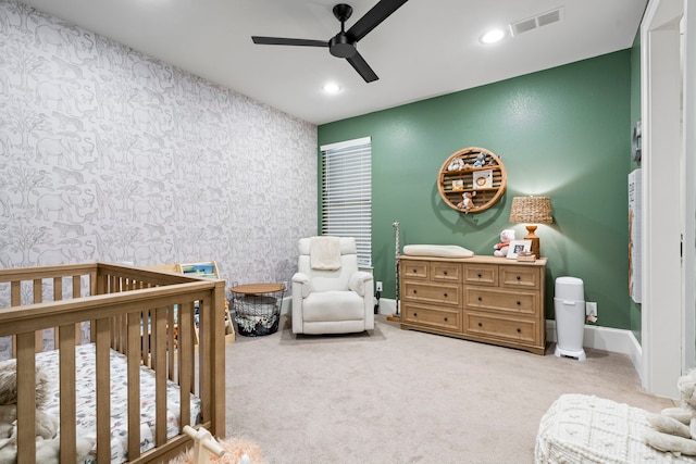 carpeted bedroom with a crib, visible vents, recessed lighting, and wallpapered walls