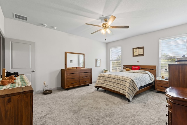 bedroom featuring light carpet, a ceiling fan, visible vents, and baseboards