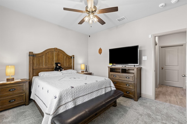 bedroom with baseboards, visible vents, light colored carpet, and ceiling fan