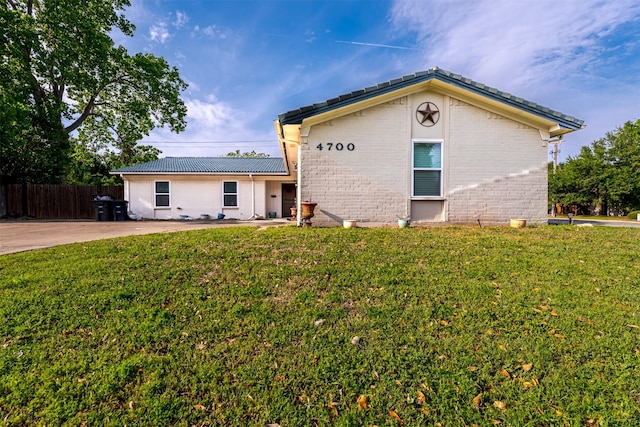 ranch-style house with fence, brick siding, and a front yard