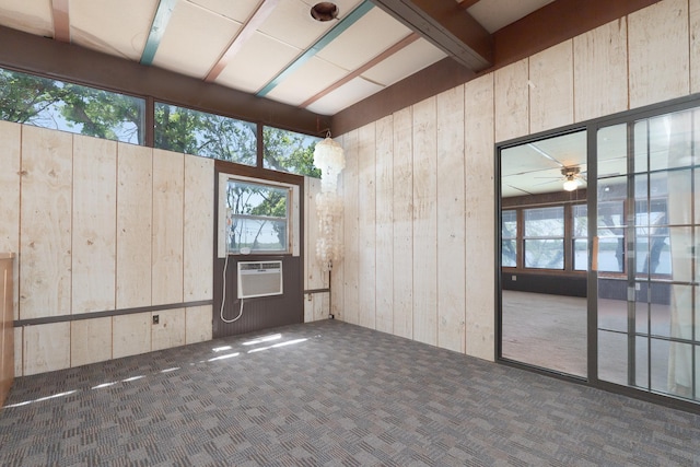 interior space with wooden walls, a wall mounted air conditioner, and carpet flooring