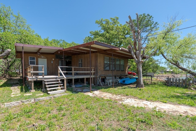 rear view of house featuring a wooden deck and fence