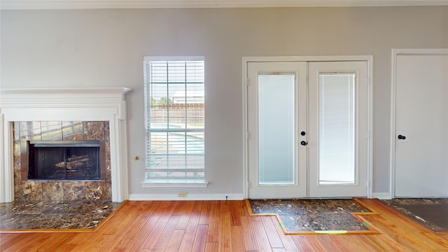 6926 Wickliff Trl, Plano, TX 75023 - unfurnished living room with french doors, a tile fireplace, wood finished floors, and baseboards