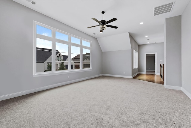 additional living space featuring carpet floors, a healthy amount of sunlight, visible vents, and baseboards