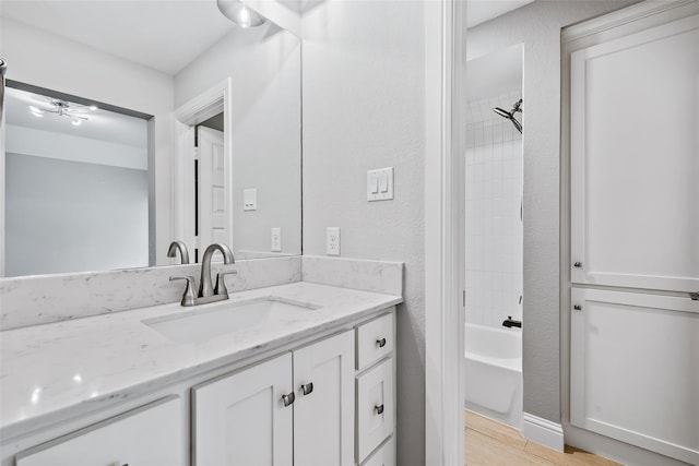 bathroom featuring wood finished floors, vanity, and bathtub / shower combination