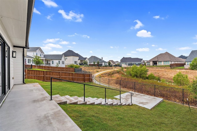 view of yard featuring fence, a residential view, and a patio